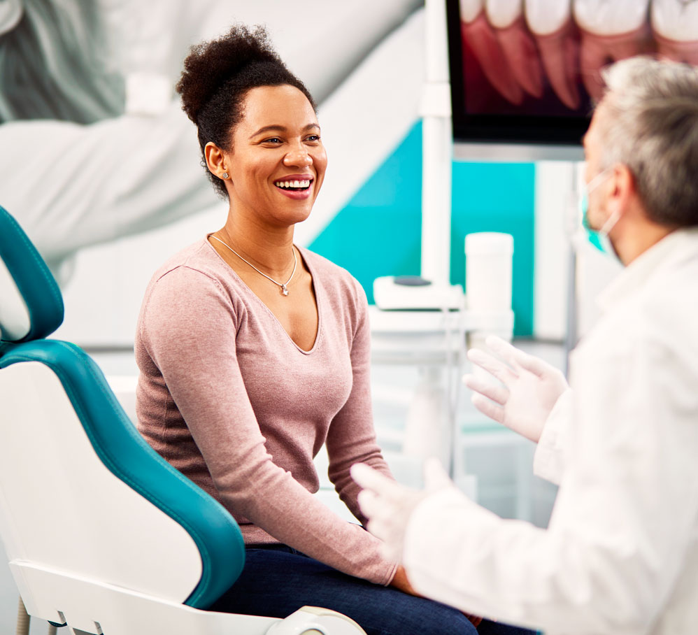 Happy Woman Talking To Dentist During Appointment At Dental Clinic